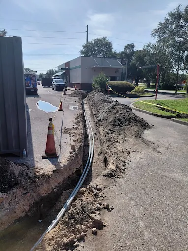 Underground conduit trench run alongside a commercial building