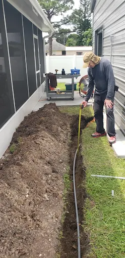 Technician measuring a residential trench for underground wire